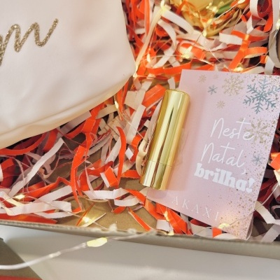 Conjunto com batom dourado, cartão de Natal rosa e papel picado colorido