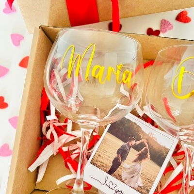 Caixa de presente com duas taças de vidro personalizadas, fitas decorativas e fotografia de casal