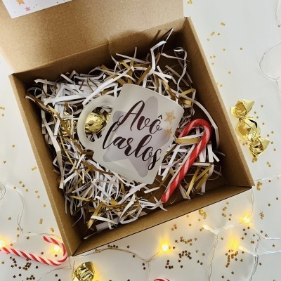 Caixa com caneca, pau-de-bengala e bombons com decoração festiva