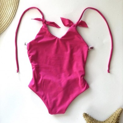 Fato de banho rosa fúcsia de uma peça com alças ajustáveis em fundo branco.