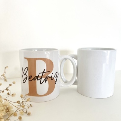Duas canecas brancas em cerâmica, uma com a letra B castanha e nome Beatriz, outra completamente branca.