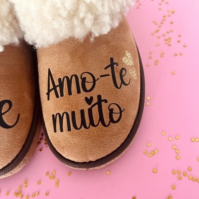 Pantufas castanhas com pelo branco e texto 