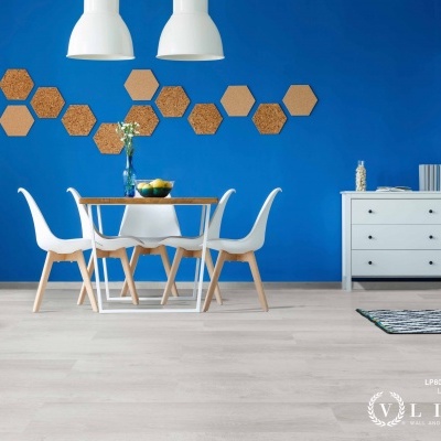 Sala de jantar com mesa, cadeiras, parede azul e cómoda branca