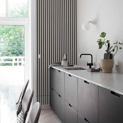 Cozinha moderna com armários cinza e bancada clara junto a janela grande