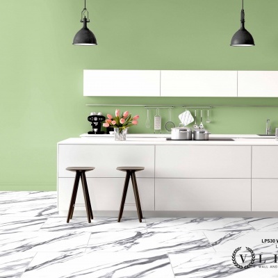 Cozinha moderna com armários brancos, banquetas de madeira escura, parede verde clara e chão em mármore branco