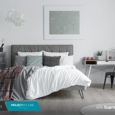 Quarto com cama, mesa e plantas em pavimento de madeira clara Suprem Oak