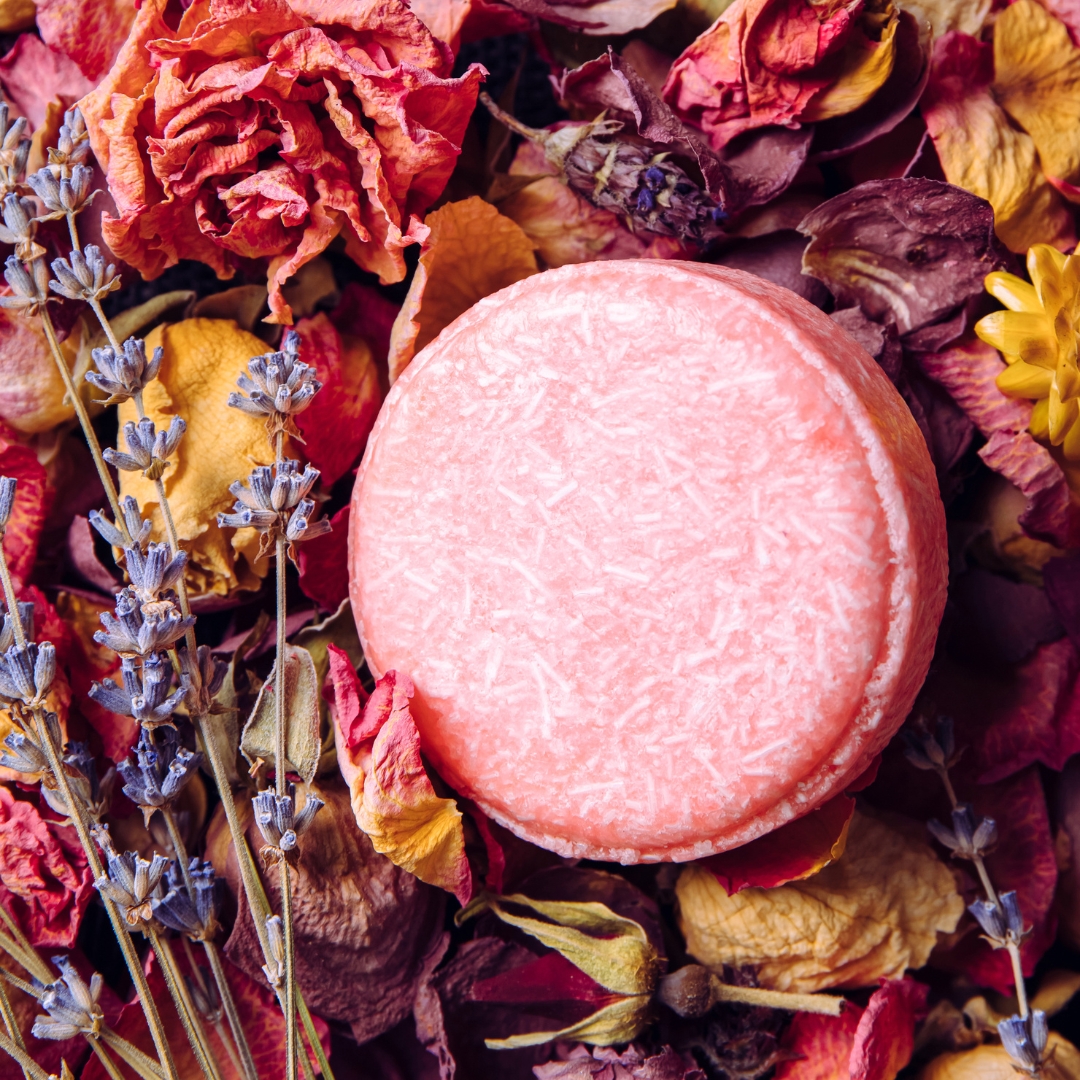 Shampoo sólido cor de rosa sobre flores secas coloridas