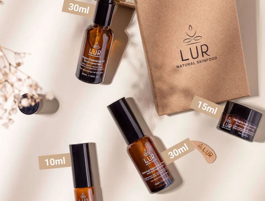 Pack 4 produtos Well-Aging (tamanho viagem) Produtos de cuidado de pele LUR em frascos castanhos com tampas pretas, embalagem de papel castanho e fundo claro