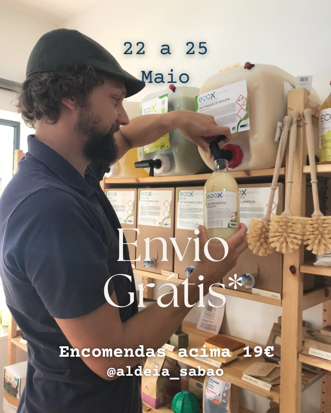 Portes grátis em encomendas acima de 19€ Homem a encher garrafa de detergente roupa ecoX em loja com recipientes grandes e escovas naturais penduradas na estante de madeira