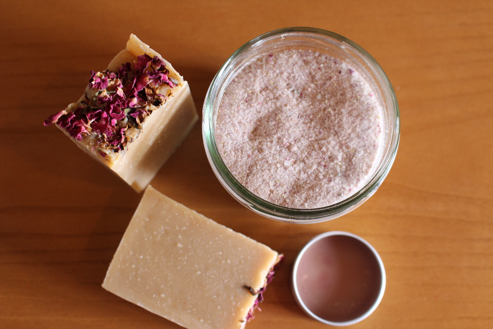 Sabonetes quadrados com flores secas ao lado de frasco com pó cor creme rosado
