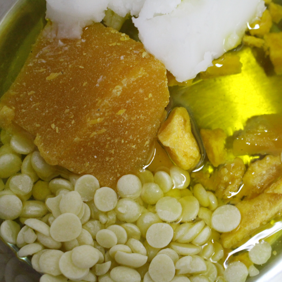 Close-up de ingredientes variados em recipiente incluindo pedaços amarelos, brancos e grânulos redondos.