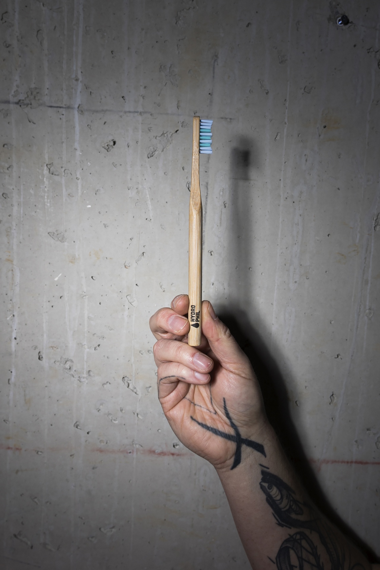 Escova de Dentes de Bambu Hydrophil - Premium Suave Escova de dentes de madeira com cerdas azuis e brancas na mão