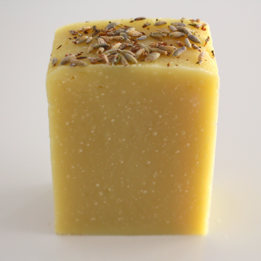 Sabonete Lavanda Produto quadrado amarelo com sementes em cima sobre fundo branco