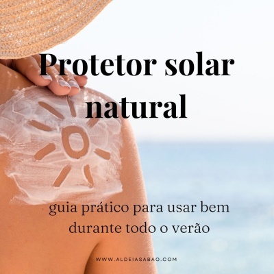 Pessoa com protetor solar em formato de sol nas costas e chapéu de palha junto ao mar.