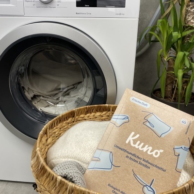 Máquina de lavar branca com cesto de roupa e detergente Kuno