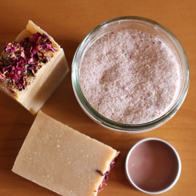 Sabonetes quadrados com flores secas ao lado de frasco com pó cor creme rosado