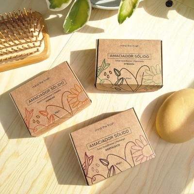 Caixas de amaciador sólido em cartão reciclado com ilustrações florais coloridas sobre superfície de madeira clara