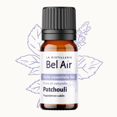 Frasco de óleo essencial de Patchouli da marca Bel Air com folhas desenhadas ao fundo
