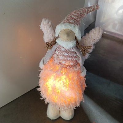 Anjo decorativo de Natal iluminado com vestido peludo cor-de-rosa claro.