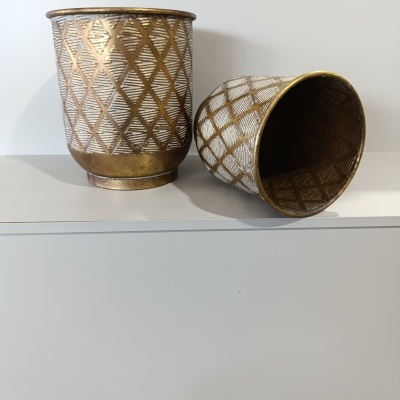 Dois recipientes cilíndricos com padrão de losangos dourados e branco.