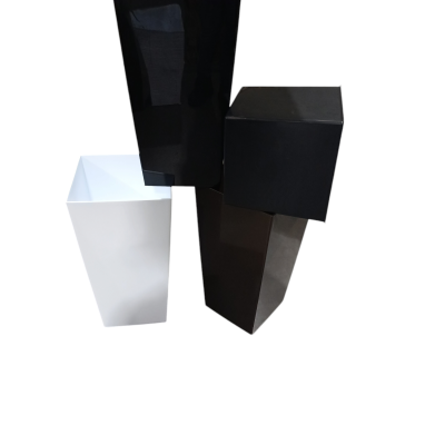 Quatro vasos quadrados de plástico, três pretos e um branco, juntos