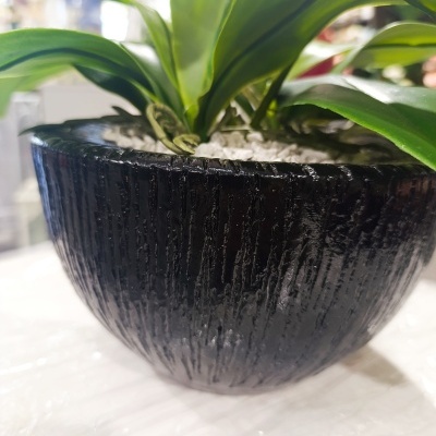 Vaso preto com plantas e flores rosas