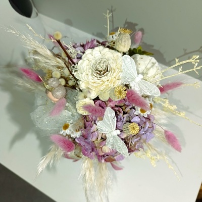 Arranjo floral de flores secas coloridas com borboletas brancas