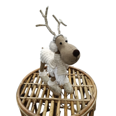 Boneco de rena decorativa em tecido bege sobre banquinho de vime trançado