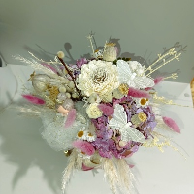 Arranjo floral com flores secas e borboletas brancas