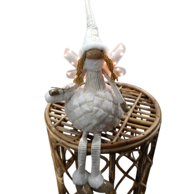 Boneca decorativa branca sentada numa mesinha de madeira redonda