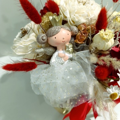 Buquê com flores brancas, secas vermelhas e castanhas e boneca princesa com vestido branco e coroa dourada