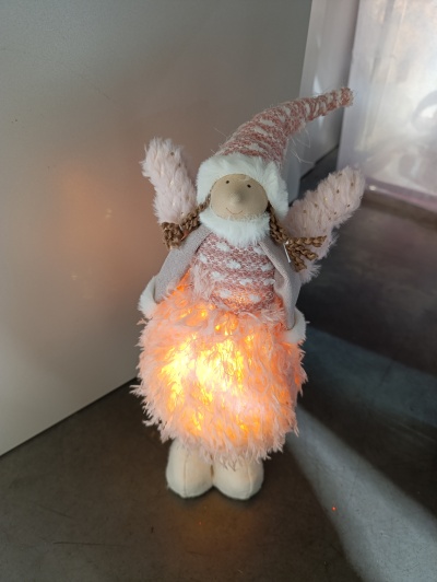 Anjo decorativo de Natal iluminado com vestido peludo cor-de-rosa claro.