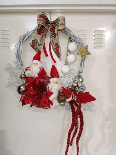 Guirlanda de Natal com bonecos de Papai Noel, folhas vermelhas, bolas e estrelas decorativas