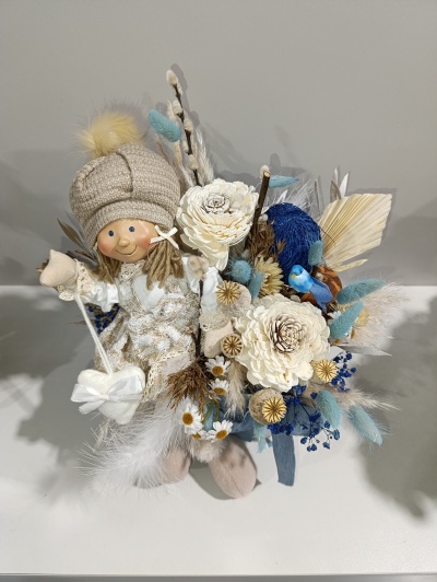 Decoração com boneca de tecido e flores secas coloridas em branco, azul e castanho
