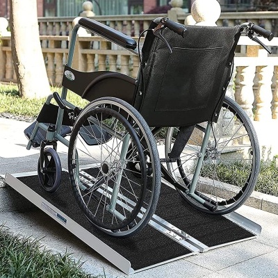 Cadeira de rodas preta sobre rampa antiderrapante metálica ao ar livre