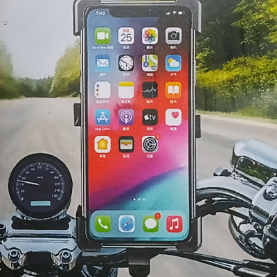 Telemóvel num suporte preto no guiador de mota numa estrada com árvores ao lado.