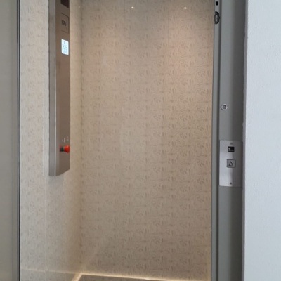 Interiores de elevador com painel metálico e luzes embutidas.