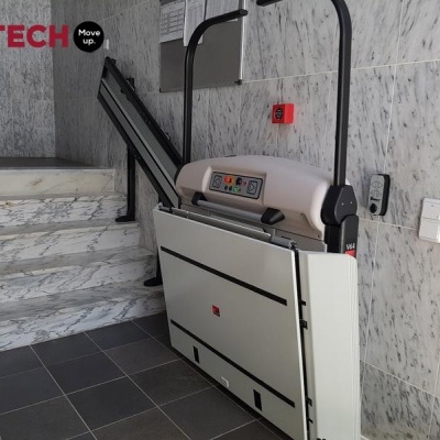 Plataforma elevatória de escadas LIFTECH instalada ao lado de escadas de mármore