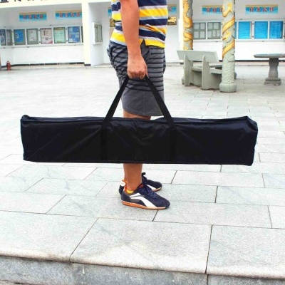 Mala de transporte preta retangular com alças a ser transportada por pessoa