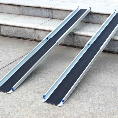 rampas de acesso de alumínio com superfície preta antiderrapante junto a escada de pedra