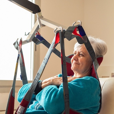Elevador de pacientes com arnês a suportar idosa sentada
