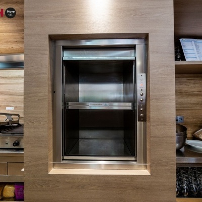 Elevador de cargas em cozinha com parede de madeira e texto LIFTECH Move your