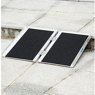 rampa dobrável metálica com superfície negra antideslizante sobre pedra cinzenta