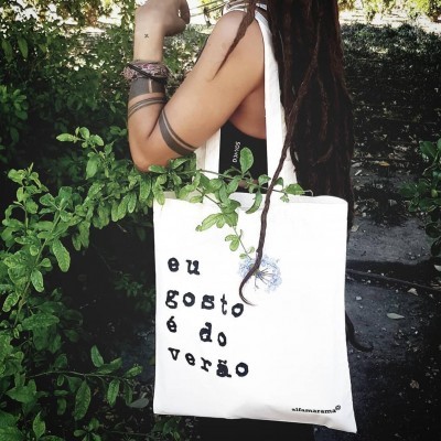 Sacola de tecido branca com texto e desenho de flor azul