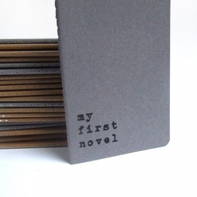 Cadernos cinzentos com texto 'my first novel'