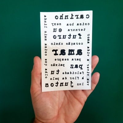 Mão a segurar cartão branco com texto preto e fundo verde