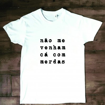 T-shirt branca com texto preto sobre fundo de madeira