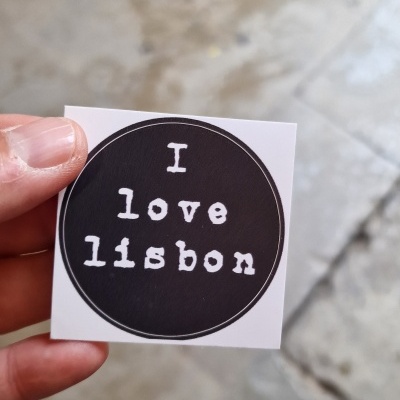 Autocolante quadrado branco com círculo preto e texto branco 'I love lisbon'