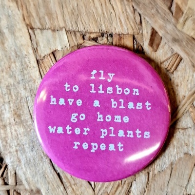 Botton rosa com texto branco sobre superfície de madeira
