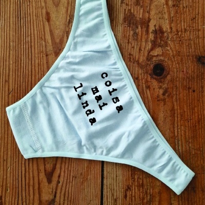 Cueca branca com texto preto sobre mesa de madeira